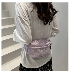 Détail du sac de poitrine en nylon violet clair avec broderie nœud blanc et fermeture éclair