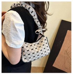 Detail of floral bow shoulder bag with beige check fabric and black ruffled strap