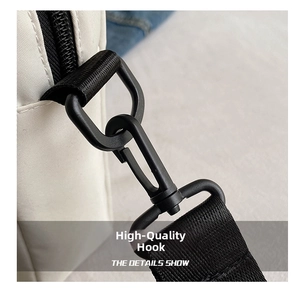 Detailed close-up of a premium black metal hook and durable nylon strap on a white bag