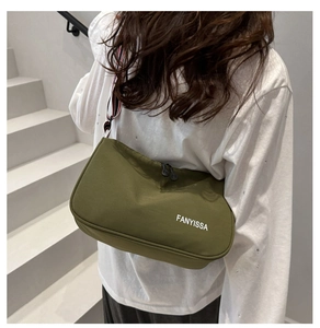 Détail du sac demi-lune vert foncé avec texte FANYISSA et large bandoulière rayée sport