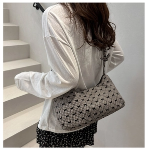 Detailed shot of checkered canvas underarm bag with bow print and ribbon strap
