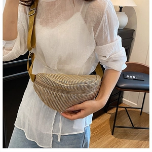 Détail d'un sac banane en strass doré champagne avec bandoulière ajustable sur un mannequin