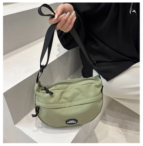 Detail of light green crescent nylon bag with adjustable strap and Lucky Fashion label