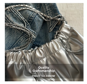 Detail of silver metallic bucket bag with drawstring closure and chain strap