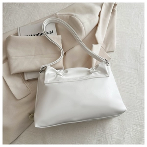 Detail of white PU leather shoulder bag with elegant pleated bow design and silver hardware