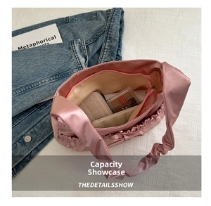 Vue intérieure du sac bandoulière en satin rose montrant la capacité pour téléphone et portefeuille