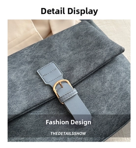 Close-up of matte textured fabric with light blue leather strap and golden buckle detail