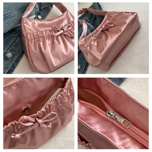 Détails du sac à bandoulière en satin rose avec nœud et fermeture magnétique