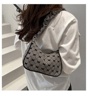 Detail of gingham shoulder bag with black bows and stylish scrunchie strap design