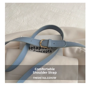 Close-up of hazy blue PU leather shoulder strap with gold buckle and stitching details
