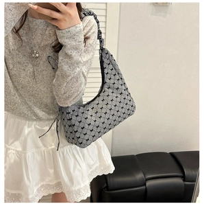 Detail of the black bow prints on a black and white checkered hobo shoulder bag