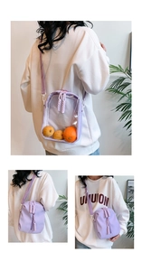 Detail view of light purple nylon crossbody bag with transparent front panel and cord zipper