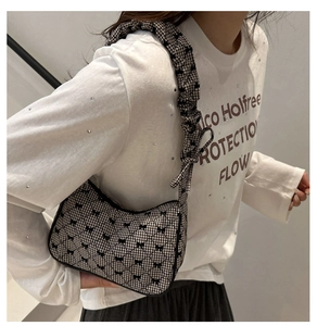 Detail of checkered fabric shoulder bag with black bows and scrunchie style strap