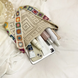 Cream crochet beach bag with colorful floral shoulder strap and summer accessories