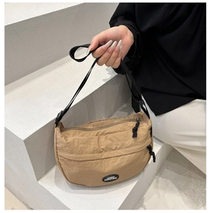 Detail of khaki nylon crescent bag with adjustable strap and Lucky Fashion logo label