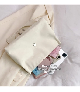 Detail view of the spacious inner compartment of the cream-colored bow shoulder bag