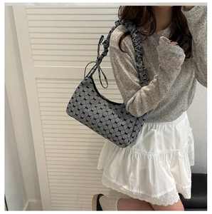Close-up of bow pattern canvas bag with trendy ruffled shoulder strap on model