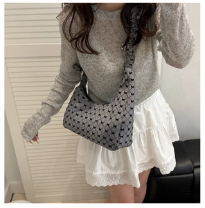 Detail of checkered shoulder bag with black bow prints and ruffled cloud strap design
