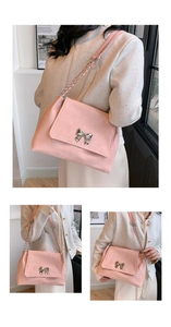 Macro view of the pink tote bag featuring a silver metal bow buckle and chain strap