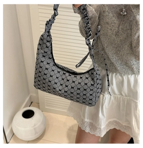Detailed view of gingham canvas bag featuring black bows and scrunchie shoulder strap