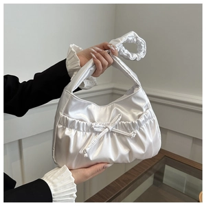 Détail du sac nuage en satin blanc avec poignée plissée et nœud décoratif élégant