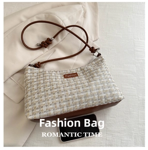 Detail of woven tweed crossbody bag with brown leather base and Fashion leather tag