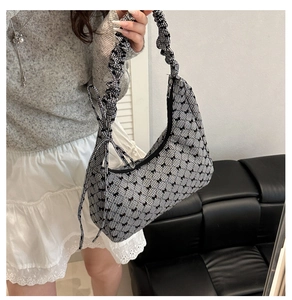 Close-up of black and white checkered canvas bag with bow patterns and ruffled handle