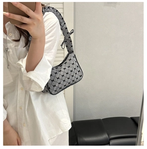 Detail of gingham baguette bag with black bows and ruffled shoulder strap