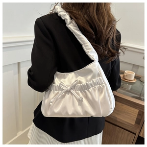 Gros plan du sac porté épaule en satin blanc avec nœud élégant et bandoulière plissée