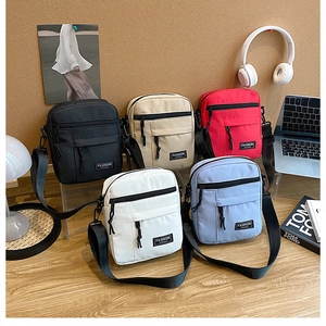 Multiple colors of nylon messenger bags arranged with lifestyle items on a desk