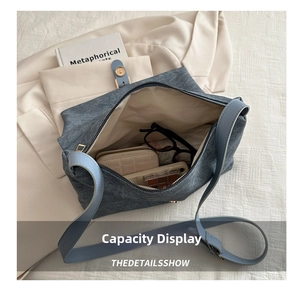 Macro view of blue canvas tote bag showing spacious interior with wallet and sunglasses
