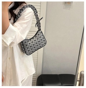 Detail of checkered shoulder bag with bow embroidery and stylish scrunchie strap