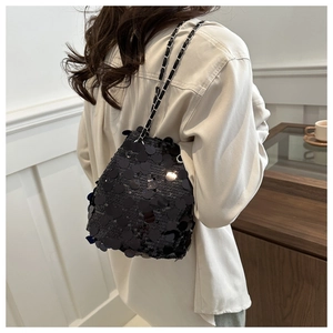 Chic black sequin bucket bag with metal chain strap worn by model for evening party style