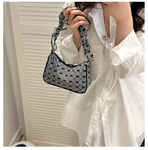 Detail of ruffled strap and gingham bow pattern on this stylish underarm bag for women