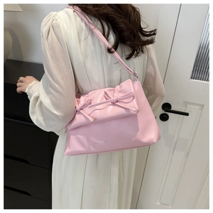 Detail view of pink PU leather tote featuring decorative bows and fashion text print