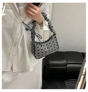 Mirror selfie showing a gingham underarm bag with black bows and a scrunchie strap