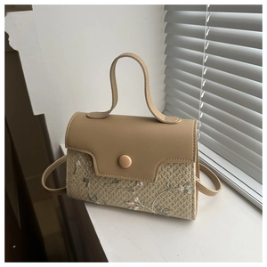 Détail du sac en paille avec broderie florale et rabat en similicuir lisse