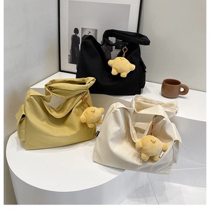 Detail view of large canvas tote bags in black, yellow, and white with plush star charms