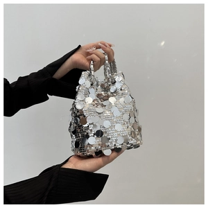 Detailed view of shimmering silver sequins and chain handle on a bucket bag
