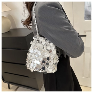 Detail of silver sequin bucket bag with metal chain strap in stylish disco evening style