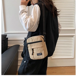 Detail of khaki nylon crossbody bag with adjustable strap and fashion instinct label