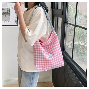Detail view of pink and white checkered canvas tote bag with EMIS logo and blue strap