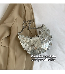 Detailed view of silver sequin crescent hobo bag with sleek metal chain on a beige blazer