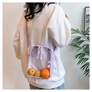 Detail of lavender transparent PVC crossbody bag with woven zippers and adjustable strap