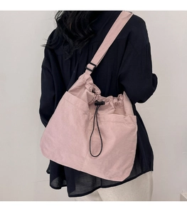 Rear view of pink nylon bucket bag with drawstring closure and dual front pockets