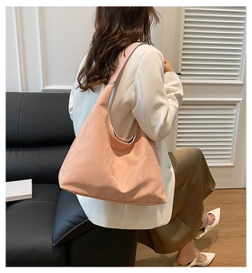 Pink large hobo shoulder bag with pleated texture styled on a white blazer and green dress