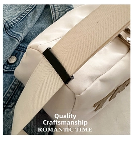 Close-up of cream canvas crossbody bag with wide strap and metallic buckle detail