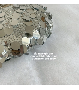 Detailed close-up of shiny silver sequins on a stylish dumpling bag surface