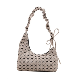 Hobo canvas shoulder bag with black bow print and pleated strap on white background