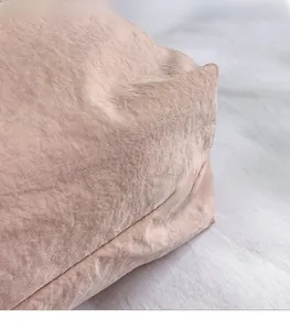 Detailed view of light pink canvas bucket bag showing lightweight textured fabric and seams